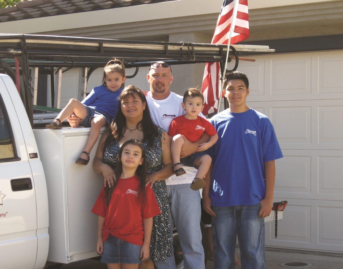 A family poses for a picture in front of an american flag.