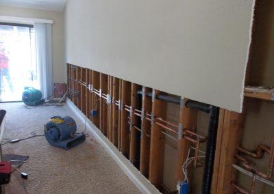 Valley City Plumbing installs a pipe in the wall.